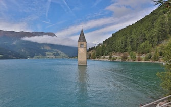 Meran, Italy September 2019: Impressions Meran and surroundings - September - 2019 Reschensee in Vinschgau with the old church of Graun, which is in the reservoir versuken | usage worldwide