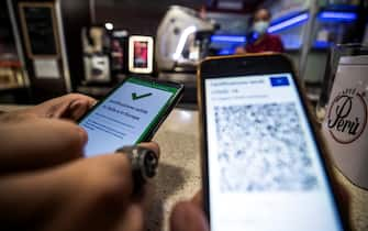 A visitor's Covid-19 Green Pass is checked at the entrance to a bar in Rome, Italy, 09 August 2021. Effective from 06 August, the so-called Green Pass is advocated by the government as the alternative to lockdowns in the light of the spreading Delta variant of the Sars-Cov-2 pandemic coronavirus. People who do not hold the certificate that identifies them as either immunised, recovered or tested for Covid-19 may be excluded from indoor venues and for access to amusement parks it is necessary to be up to date with anti-covid-19 vaccinations, or have a negative swab in the last 48 hours. ANSA/ANGELO CARCONI