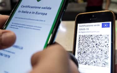 A visitor's Covid-19 Green Pass is checked at the entrance to a bar in Rome, Italy, 09 August 2021. Effective from 06 August, the so-called Green Pass is advocated by the government as the alternative to lockdowns in the light of the spreading Delta variant of the Sars-Cov-2 pandemic coronavirus. People who do not hold the certificate that identifies them as either immunised, recovered or tested for Covid-19 may be excluded from indoor venues and for access to amusement parks it is necessary to be up to date with anti-covid-19 vaccinations, or have a negative swab in the last 48 hours. ANSA/ANGELO CARCONI