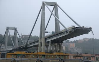 1016533884 A picture taken on August 14, 2018 in Genoa shows a view of the Ponte Morandi motorway bridge, after one of its section collapsed injuring several people. - Rescuers scouring through the wreckage after part of a viaduct of the A10 freeway collapsed said there were "tens of victims", while images from the scene showed an entire carriageway plunged on to railway lines below. (Photo by ANDREA LEONI / AFP) (Photo credit should read ANDREA LEONI/AFP via Getty Images)
