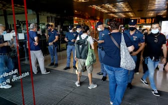 Law enforcement officers are seen next to passengers departing from the Porta Garibaldi railway station in Milan, Italy, 01 September 2021. The government's COVID-19 Green Pass vaccine passport became compulsory for travel on long-distance trains, buses and domestic airplanes on Wednesday amid an alert for announced protests by anti-vaxxers. Police heightened security at train stations overnight against the anti-vaxxers, who have threatened to block trains Wednesday afternoon. ANSA/MOURAD BALTI TOUATI