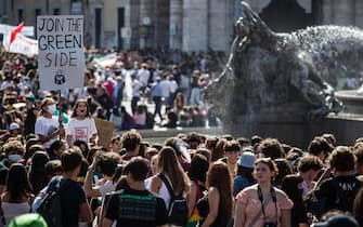 Protesters with signs and slogans during the demonstration Fridays for Future for the global climate strike in Rome, Italy, 24 September 2021. ANSA/ANGELO CARCONI