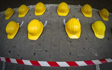 Iniziativa sindacale della Cisl di Napoli nella giornata mondiale per la sicurezza sul lavoro con l'esposizione su un marciapiede di 27 caschi gialli, lo stesso numero di morti sul lavoro registato nella provincia partenopea nel 2017, 27 aprile 2018. ANSA / CIRO FUSCO
