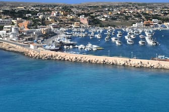 A photo taken from behind the plane window of a commercial flight shows the touristic port of Lampedusa on September 25, 2018. - Five years after the worst shipwreck of its history, the largest island of the Italian Pelagie Islands in the Mediterranean Sea, Lampedusa relies on the flood of tourists to make a fresh start, though it might become a gateway to Europe again. (Photo by Alberto PIZZOLI / AFP) / TO GO WITH AFP STORY BY FANNY CARRIER        (Photo credit should read ALBERTO PIZZOLI/AFP via Getty Images)