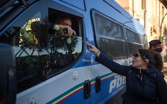 ROME, ITALY - OCTOBER 15: A woman hands flowers to Police officers during a demonstration organized by No Green Pass, No Vax and far-right movements against the Green Pass, following the new decree outlined by Italian Government, at Circo Massimo, on October 15, 2021 in Rome, Italy. As of October 15, the 23 million civil servants and employees in Italy must present proof of vaccination or a negative Covid-19 test to work. A measure that could paralyze certain sectors of the economy. (Photo by Antonio Masiello/Getty Images)