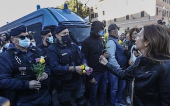 ROME, ITALY, OCTOBER 15:
Women offer flowers to police officers during a demonstration against the obligation of the green pass certification at the Circus Maximus in Rome, Italy, on October 15, 2021. Starting from October 15 the Covid-19 green certification is mandatory in Italy to access workplaces, amid several protests. (Photo by Riccardo De Luca/Anadolu Agency via Getty Images)