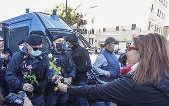1235898070 ROME, ITALY, OCTOBER 15:
Women offer flowers to police officers during a demonstration against the obligation of the green pass certification at the Circus Maximus in Rome, Italy, on October 15, 2021. Starting from October 15 the Covid-19 green certification is mandatory in Italy to access workplaces, amid several protests. (Photo by Riccardo De Luca/Anadolu Agency via Getty Images)