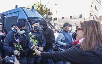 ROME, ITALY, OCTOBER 15:
Women offer flowers to police officers during a demonstration against the obligation of the green pass certification at the Circus Maximus in Rome, Italy, on October 15, 2021. Starting from October 15 the Covid-19 green certification is mandatory in Italy to access workplaces, amid several protests. (Photo by Riccardo De Luca/Anadolu Agency via Getty Images)