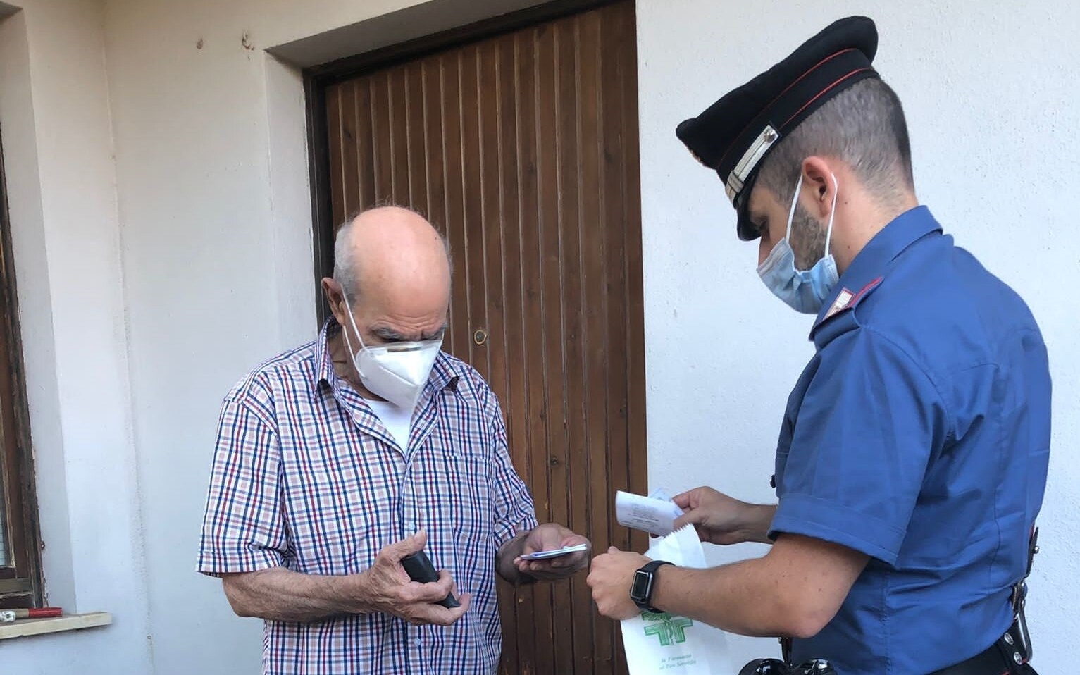 I carabinieri aiutano l'anziano, consegnandogli il farmaco. I carabinieri aiutano l'anziano, consegnandogli il farmaco