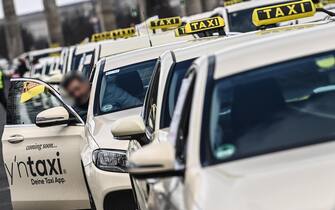 epa09023700 Lines of taxis are parked on 'Strasse des 17. Juni' street during a taxi driver protest in Berlin, Germany, 19 February 2021. Taxi drivers protest as they oppose competition from service companies like Uber and call for a reform of the passenger transport law.  EPA/FILIP SINGER