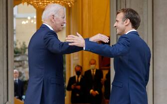 French President Emmanuel Macron (R) welcomes US President Joe Biden (L) before their meeting at the French Embassy to the Vatican in Rome on October 29, 2021. (Photo by Ludovic MARIN / AFP) (Photo by LUDOVIC MARIN/AFP via Getty Images)