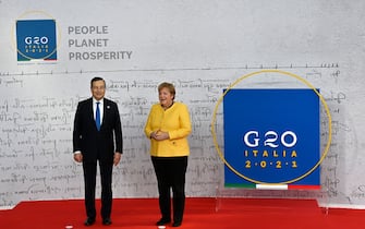 Italy's Prime Minister, Mario Draghi (L) greets German outgoing Chancellor Angela Merkel as he arrives for the G20 of World Leaders Summit on October 30, 2021 at the convention center "La Nuvola" in the EUR district of Rome. (Photo by Alberto PIZZOLI / AFP) (Photo by ALBERTO PIZZOLI/AFP via Getty Images)