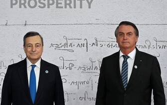 TOPSHOT - Italy's Prime Minister, Mario Draghi (L) greets Brazilian President Jair Bolsonaro as he arrives for the G20 of World Leaders Summit on October 30, 2021 at the convention center "La Nuvola" in the EUR district of Rome. (Photo by Alberto PIZZOLI / AFP) (Photo by ALBERTO PIZZOLI/AFP via Getty Images)