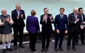 (From L) Indian Prime Minister Narendra Modi, Australian Prime Minister Scott Morrison, German Chancellor Angela Merkel, Italian Prime Minister Mario Draghi, French President Emmanuel Macron, British Prime Minister Boris Johnson and Director general, Food and Agriculture Organization (FAO), Qu Dongyu visit the Trevi fountain in central Rome on October 31, 2021 on the sidelines of the G20 of World Leaders Summit. (Photo by Andreas SOLARO / AFP) (Photo by ANDREAS SOLARO/AFP via Getty Images)