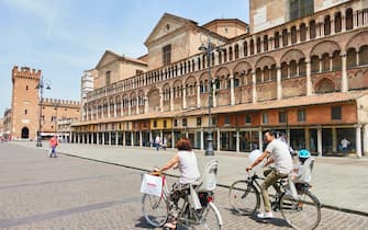 FERRARA, ITALY - JUNE 8:  Old men on a bicycle and tourists in the historic center at Piazza Cattedrale on June 8, 2019 in Ferrara, Italy. (Photo by EyesWideOpen/Getty Images)