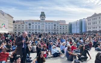 Il corteo di manifestanti è tornato in piazza Unità d'Italia, dove in molti, in silenzio, si sono seduti a terra, Trieste, 18 Ottobre 2021. ANSA/ALICE FUMIS
