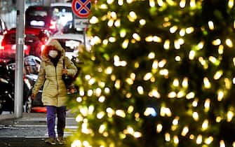 Passanti con le mascherine attraversano piazza Municipio, a Napoli, addobbata per le feste con un grande albero di Natale illuminato, 17 novembre 2021. ANSA / CIRO FUSCO
