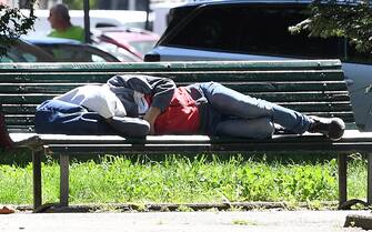 povertà Un senza fissa dimora riposa su una panchina a Milano, 19 maggio 2021. ANSA/DANIEL DAL ZENNARO