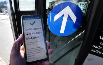 A valid Green Pass for Italy and EU the is diplayed on a smartphone while Italian Police and staff of the Trnsport Metro Company (AMT) check the QR code confirming that people received the Covid-19 vaccine, at the Brignole bus stop in Genoa, Italy, 06 December 2021. The measures on the 'enhanced' green certificate (obtainable only with vaccination or recovery) come into effect from 06 December 2021 until 15 January 2022. EPA-ANSA/LUCA ZENNARO