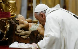 Pope Francis kisses a figurine of baby Jesus during the Christmas Holy Mass in Saint Peter's Basilica at the Vatican, 24 December 2021.ANSA/FABIO FRUSTACI