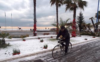 Un uomo in bici sul lungomare di Viareggio