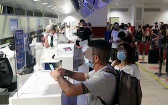 Bologna.Turisti in partenza per le vacanze all'aeroporto Guglielmo Marconi. Nella foto due passeggeri mostrano il green pass mentre fanno il check-in (Bologna - 2021-08-11, Roberto Brancolini) p.s. la foto e' utilizzabile nel rispetto del contesto in cui e' stata scattata, e senza intento diffamatorio del decoro delle persone rappresentate