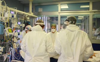 Health workers wearing overalls and protective masks at work in the intensive care unit of the hospital of Cremona amid the Covid-?19 coronavirus pandemic, in Cremona, northern Italy, 26 December 2021. Italian Premier Mario Draghi's government has brought in a series of new COVID-19 prevention measures, including the obligation to wear facemasks outdoors, due to the sharp upswing in contagion and the arrival of the Omicron variant. It was already mandatory for people to wear facemasks in enclosed public spaces. The government has also decide to close Italy's night clubs and dance halls and ban open-air parties that attract crowds of people until January 31. It has also reduced the duration of the 'Super Green Pass' health certificate for people who are vaccinated for the coronavirus from nine to six months. 
ANSA/ FILIPPO VENEZIA