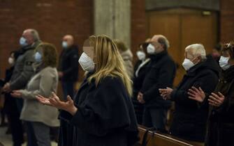People wearing a face mask pray during Sunday Mass in the San Giuseppe church in Seriate, near Bergamo, Lombardy, on February 14, 2021. - On February 21, 2021, Italy's Lombardy region will mark one year since it recorded the first locally acquired case of Covid-19 in Codogno, in what became the first major outbreak in Europe. (Photo by Piero CRUCIATTI / AFP) (Photo by PIERO CRUCIATTI/AFP via Getty Images)
