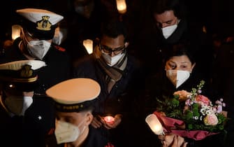 Indian Kevin Rebello (C), who lost his brother in the 2012 Costa Concordia shipwreck, attends with shipwreck survivors, relatives of victims, local residents and officials a torchlight procession in the port of Giglio on January 13, 2022, marking the tenth anniversary of the January 13, 2012 Costa Concordia shipwreck off Giglio island, Tuscany, that killed 32. (Photo by Filippo MONTEFORTE / AFP) (Photo by FILIPPO MONTEFORTE/AFP via Getty Images)