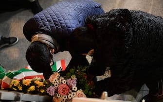 Indian Kevin Rebello (L), who lost his brother in the 2012 Costa Concordia shipwreck, lays a wreath at a memorial for the victims as he attends with shipwreck survivors, relatives of victims, local residents and officials a torchlight procession in the port of Giglio on January 13, 2022, marking the tenth anniversary of the January 13, 2012 Costa Concordia shipwreck off Giglio island, Tuscany, that killed 32. (Photo by Filippo MONTEFORTE / AFP) (Photo by FILIPPO MONTEFORTE/AFP via Getty Images)
