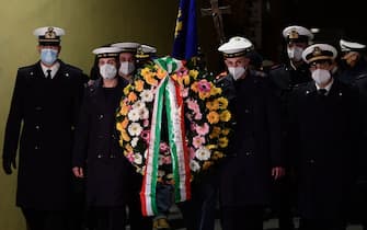Members of the port authority carry a wreath during a torchlight procession in the port of Giglio on January 13, 2022, marking the tenth anniversary of the January 13, 2012 Costa Concordia shipwreck off Giglio island, Tuscany, that killed 32. (Photo by Filippo MONTEFORTE / AFP) (Photo by FILIPPO MONTEFORTE/AFP via Getty Images)