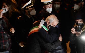The mayor of Giglio island, Sergio Ortelli (C) hugs a person as  shipwreck survivors, relatives of victims, local residents and officials take part in a torchlight procession in the port of Giglio on January 13, 2022, marking the tenth anniversary of the January 13, 2012 Costa Concordia shipwreck off Giglio island, Tuscany, that killed 32. (Photo by Filippo MONTEFORTE / AFP) (Photo by FILIPPO MONTEFORTE/AFP via Getty Images)