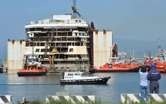 La Costa Concordia dopo una notte di navigazione trainata dai rimorchiatori giunge nella banchina dove  verrà smantellata definitivamente, Genova, 12 maggio 2015. ANSA/ PAOLO ZEGGIO