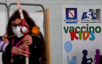 Durante i minuti di attesa, previsti dopo  aver ricevuto il vaccino anti covid, bambini giocano con gli animatori  nella palestra della scuola elementare 'Piscicelli' di Napoli trasformata in hub vaccinale.12 gennaio 2022 ANSA/ CIRO FUSCO
