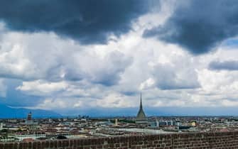 Nuvole nere minacciose di pioggia incombono sulla città e su una coppia di novelli sposi sul monte dei Cappuccini. Torino 14 maggio 2021 ANSA/TINO ROMANO 