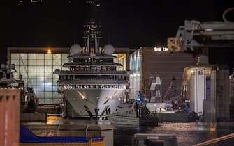 Italy's financial police patrol boat is seen in front of the multi-million-dollar mega yacht Scheherazade, docked at the Tuscan port of Marina di Carrara, Tuscany, on May 6, 2022, after its basin was reflooded. - The mega yacht at the centre of a mystery over its ownership appeared ready to set sail from Italy Friday, as speculation swirls it might belong to the Russian president. "Scheherazade", worth an estimated $700 million, is the subject of a probe into its ownership by Italy's financial police. (Photo by Federico SCOPPA / AFP) (Photo by FEDERICO SCOPPA/AFP via Getty Images)