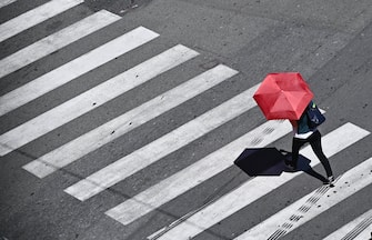 Una donna cerca di proteggersi dal grande caldo, oltre 30 gfradi, con il suo ombrello in giro per la citta'. Genova, 10 giugno 2022