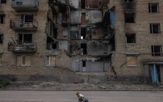 epaselect UKRAINE RUSSIA CONFLICT epaselect epa10018734 A child plays in front of a damaged residential building in Horenka, Kyiv (Kiev) region, Ukraine, 17 June 2022. Several towns and villages in the northern part of the Kyiv region became battlefields, heavily shelled, causing death and damage when Russian troops tried to reach the Ukrainian capital Kyiv in February and March 2022. Russian troops on 24 February entered Ukrainian territory, starting a conflict that has provoked destruction and a humanitarian crisis. EPA/ROMAN PILIPEY