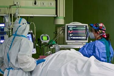 Members of the medical staff wearing personal protective equipment (PPE) tend to a patient in the Covid-19 intensive care unit (ICU) of the Bolognini hospital in Seriate, Bergamo, on March 12, 2021, amid the Covid-19 (novel coronavirus) pandemic. - At the Seriate hospital, near Bergamo, the intensive care unit is once again full, its eight beds occupied by coronavirus patients, even if the numbers are not as high as last year. "Covid is more aggressive now, with many cases of the new English variant," said the director of the unit, noting the relatively young age of his patients. (Photo by Miguel MEDINA / AFP) (Photo by MIGUEL MEDINA/AFP via Getty Images)