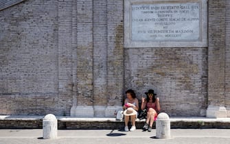 Tourists look for shade at the borrom of the Trinita dei Monti church in central Rome on June 18, 2022. (Photo by Tiziana FABI / AFP) (Photo by TIZIANA FABI/AFP via Getty Images)