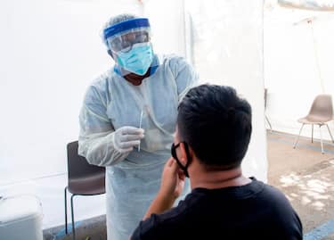 A health worker takes a nasal swab sample at a COVID-19 testing site at St. John's Well Child and Family Center, amid the novel coronavirus pandemic, July 24, 2020, in Los Angeles, California. - The coronavirus pandemic hit grim new milestones July 23, with cases topping four million in the United States and three million in Europe as fresh spikes from Belgium to Tokyo to Melbourne forced new restrictions on citizens. (Photo by VALERIE MACON / AFP) (Photo by VALERIE MACON/AFP via Getty Images)