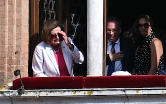 US Speaker of the House Nancy Pelosi (L) stands at a window overlooking the Piazza del Campo prior to the historical Italian horse race "Palio di Siena" on July 2, 2022 in Siena, Tuscany. (Photo by Alberto PIZZOLI / AFP) (Photo by ALBERTO PIZZOLI/AFP via Getty Images)