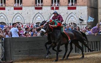 Italian jockey Giovanni Atzeni (Front) riding Zio Frac for the Drago district, and Italian jockey Jonatan Bartoletti riding Viso d'Angelo for the Torre ditrict, ride during the historical Italian horse race "Palio di Siena" on July 2, 2022 in Siena, Tuscany. (Photo by Alberto PIZZOLI / AFP) (Photo by ALBERTO PIZZOLI/AFP via Getty Images)