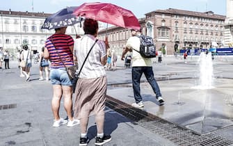 Ombrellini, ventagli e ventole portati per contrastare l'emergenza caldo: i termometri segnano 34 gradi nel pomeriggio del 14 luglio 2022 a Torino, in centro ANSA/JESSICA PASQUALON