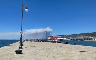 Passeggeri si imbarcano su una motonave diretta a Grado per lasciare Trieste a causa dell'incendio sul Carso, 20 luglio 2022. ANSA/ ALICE FUMIS