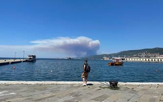 Passeggeri si imbarcano su una motonave diretta a Grado per lasciare Trieste a causa dell'incendio sul Carso, 20 luglio 2022. ANSA/ ALICE FUMIS