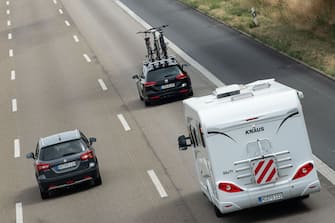 30 July 2022, Hessen, Kassel: A car with bicycles and a motorhome drive over the highway A7. On 29.07.2022 the summer vacations have also started in the last federal states. Photo: Swen PfÃ¶rtner/dpa (Photo by Swen PfÃ¶rtner/picture alliance via Getty Images)
