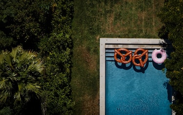 Inflatable pretzels and a donut are seen floating in a backyard pool at a home off Summit Drive in this aerial photograph taken over Los Angeles, California, U.S., on Friday, July 10, 2015. Photographer: Patrick T. Fallon/Bloomberg