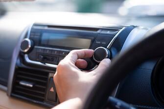 Man is using radio and control volume in the car