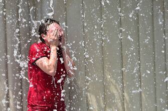 A tourist cools off in a fountain in Milan on July 4, 2015 as a major heatwave spreads throughout Europe with temperatures hitting nearly 40 degrees. AFP PHOTO / GIUSEPPE CACACE / AFP / GIUSEPPE CACACE        (Photo credit should read GIUSEPPE CACACE/AFP via Getty Images)